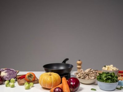Studio composition of fresh vegetables and a frying pan, ideal for healthy cooking and recipe preparation.